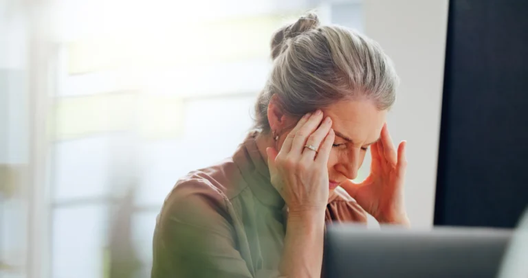 Woman holding her temples while experiencing a headache